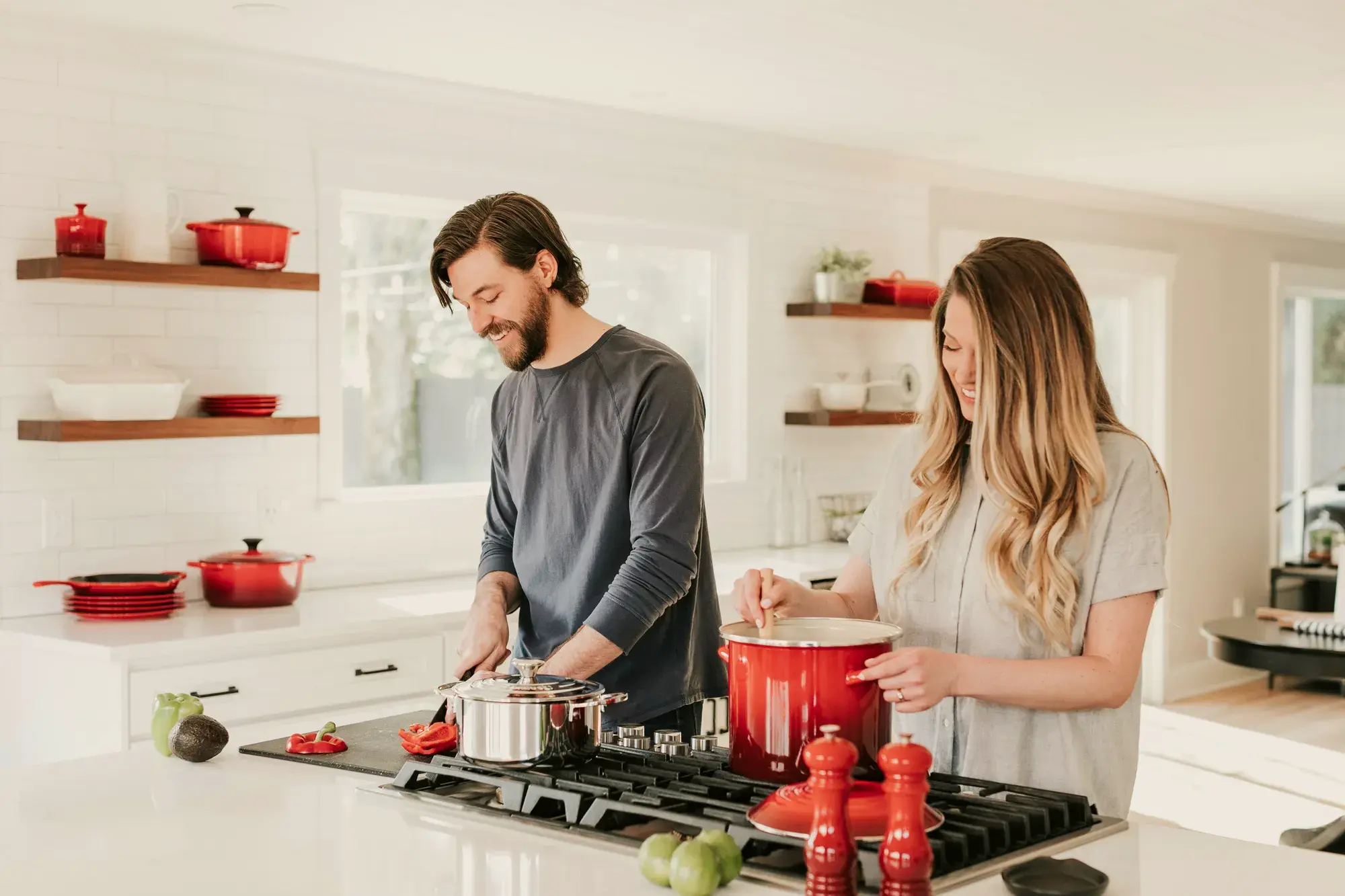 A couple cooking together in a warm, lived-in kitchen