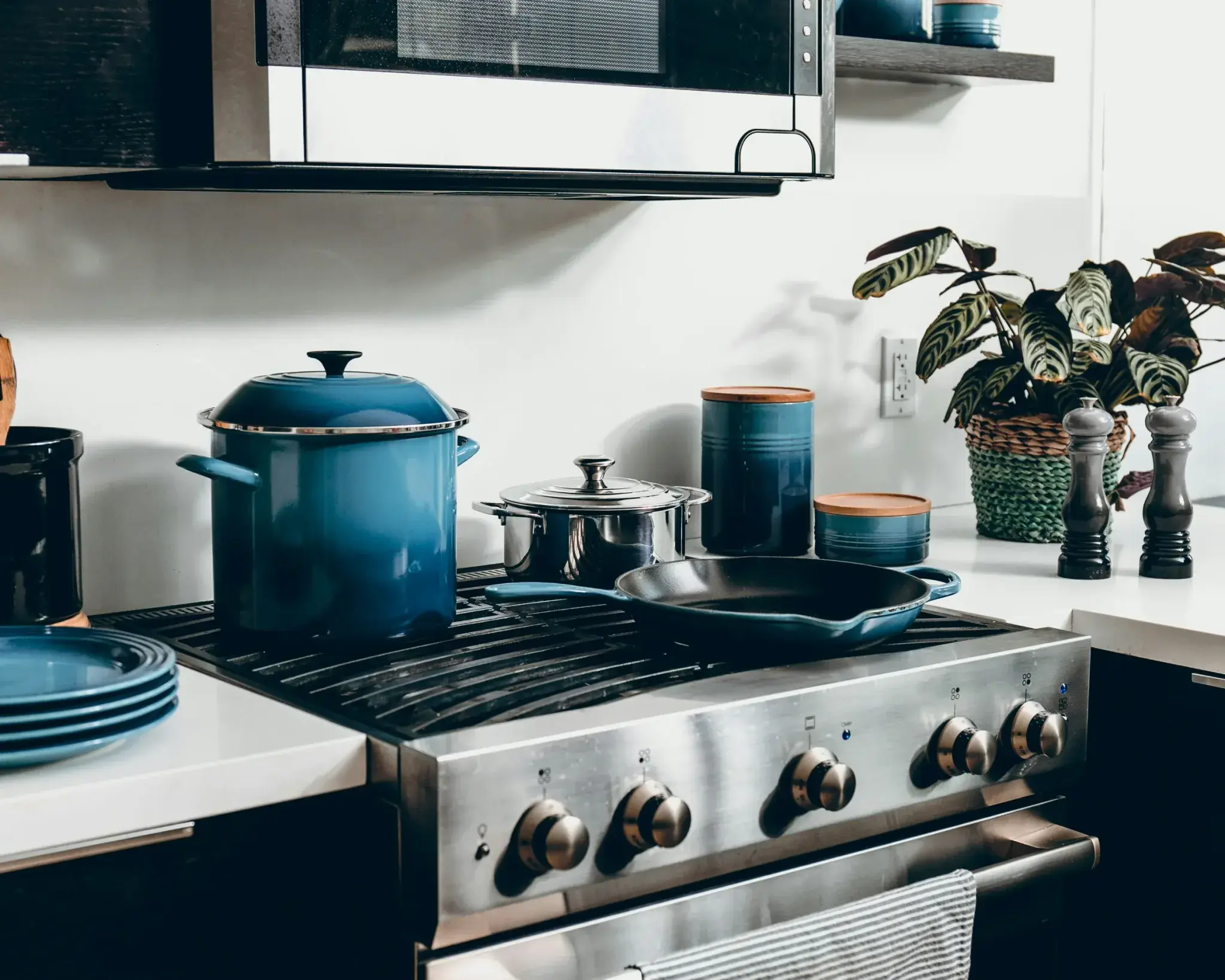 A stainless steel range cooker hob with blue enamel pans on top
