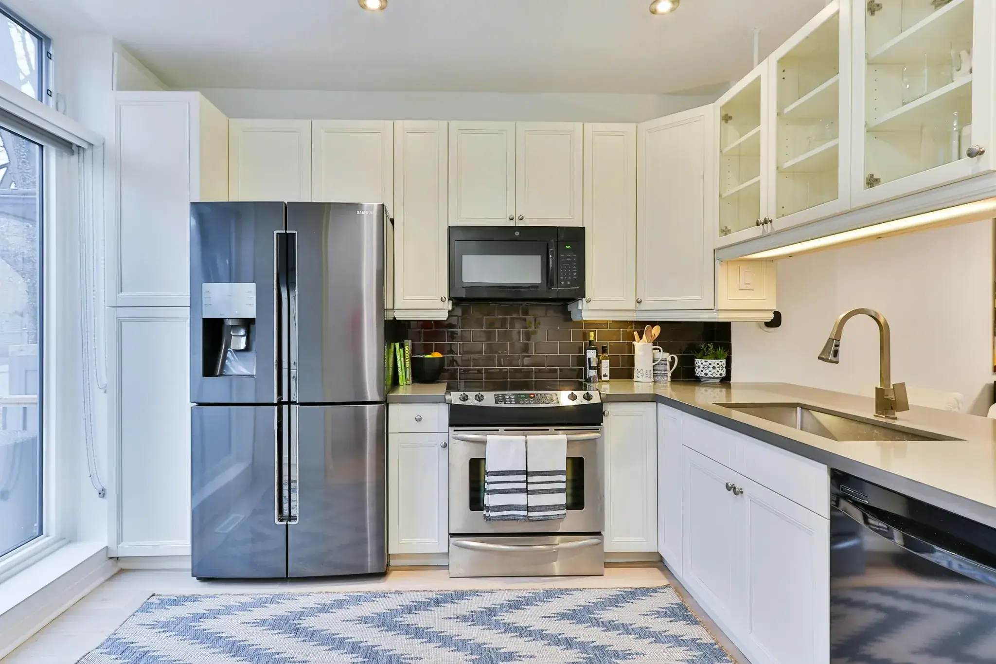 A domestic kitchen fitted with a fridge freezer, oven, microwave and dishwasher