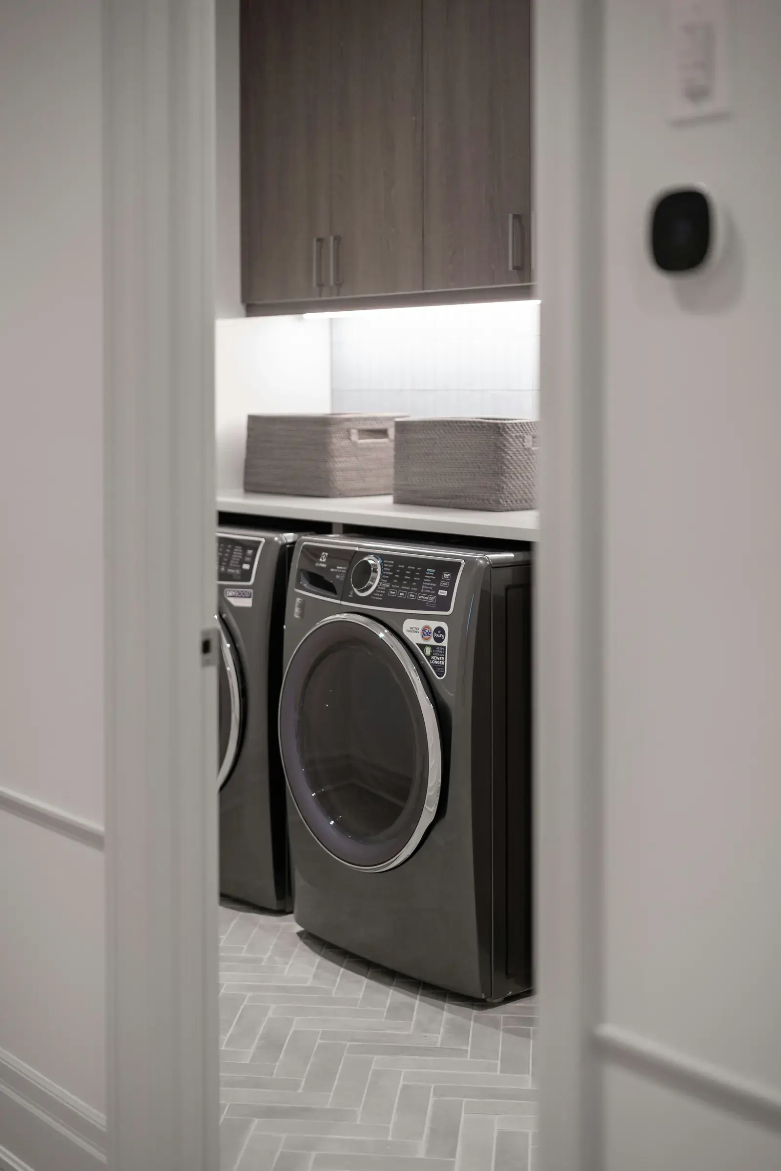 A washing machine and tumble dryer installed side by side in a utility cupboard